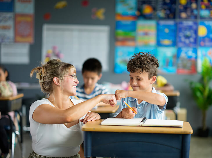 teacher fist bumping student
