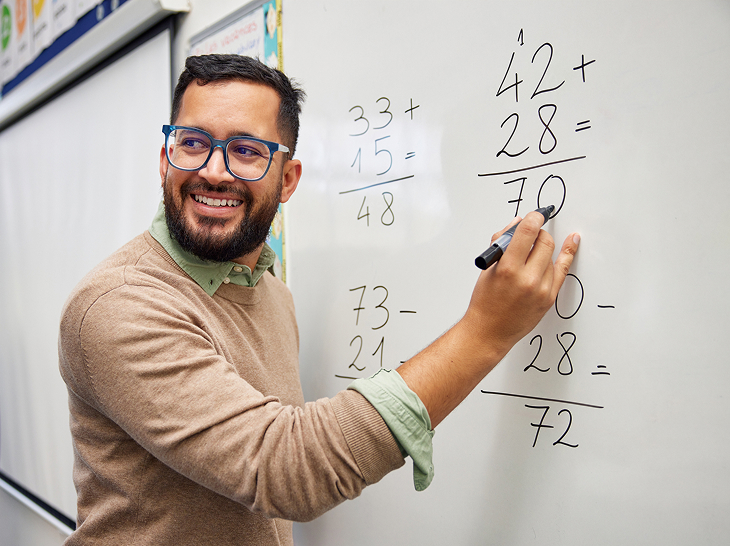 teacher doing a math on a whiteboard
